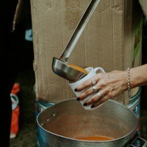 a woman is pouring something into a pot